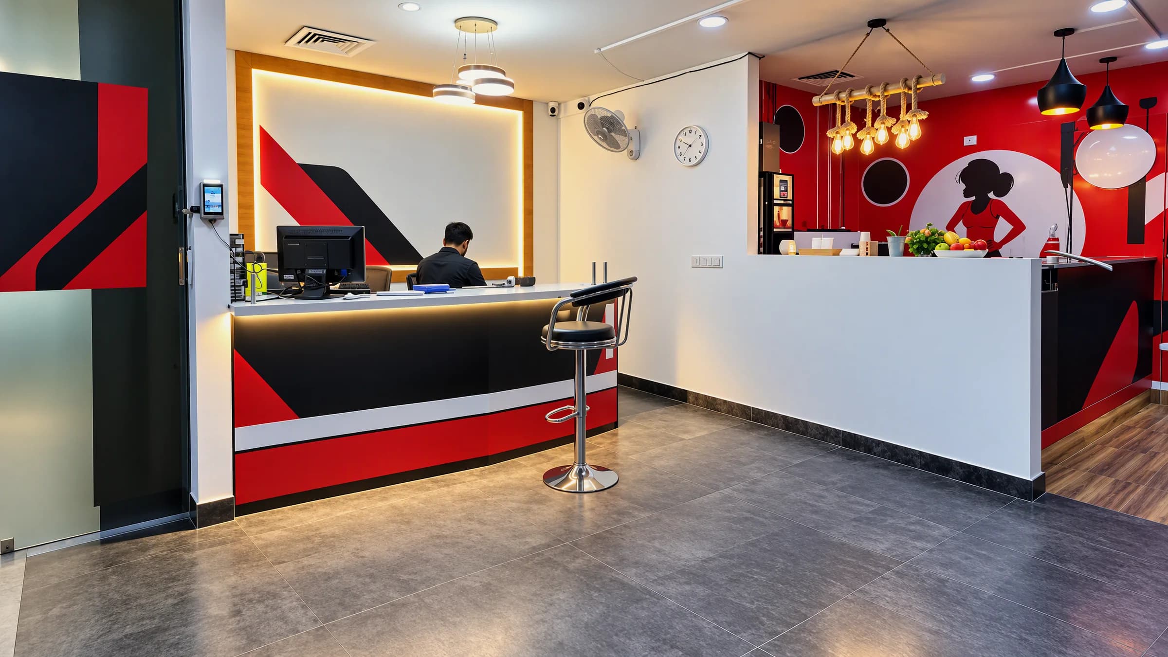 A gym front desk and reception counter with a staff member at work, a café counter beside it
